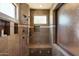 Tiled shower with glass door, built-in seat, shelving, and a shower head at 7731 E Soaring Eagle Way, Scottsdale, AZ 85266