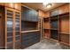 Spacious walk-in closet with custom dark wood cabinets and shelves at 7731 E Soaring Eagle Way, Scottsdale, AZ 85266