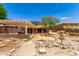 Backyard featuring gravel landscaping, solar panels, covered patio, and desert foliage at 82 N 221St Ave, Buckeye, AZ 85326