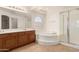 Bright bathroom with a soaking tub, glass shower, and double sink vanity at 82 N 221St Ave, Buckeye, AZ 85326