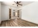 Bedroom with wood floors, ceiling fan, and decorative doors to an adjacent room at 82 N 221St Ave, Buckeye, AZ 85326