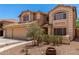 Warm toned, two-story home featuring a two-car garage and desert landscaping at 82 N 221St Ave, Buckeye, AZ 85326