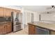 Bright kitchen with stainless steel refrigerator, granite countertops, and wood cabinets, enhancing cooking experience at 82 N 221St Ave, Buckeye, AZ 85326