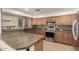 A beautifully remodeled kitchen with granite counters, wood cabinets, and stainless steel appliances, perfect for modern living at 82 N 221St Ave, Buckeye, AZ 85326
