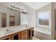 Bathroom with double sink vanity, large mirror, soaking tub, and tile flooring at 8540 W Ocotillo Rd, Glendale, AZ 85305