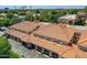 Top-down view of a home featuring a red tile roof and garages, with lush greenery and mature trees at 8653 E Royal Palm Rd # 1030, Scottsdale, AZ 85258