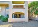 Charming condo exterior featuring an arched window and decorative brickwork, surrounded by lush greenery and landscaping at 8653 E Royal Palm Rd # 1030, Scottsdale, AZ 85258