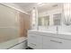 Modern bathroom boasts a dual sink vanity, decorative lighting and a glass-enclosed shower/tub at 8738 E Vista Dr, Scottsdale, AZ 85250