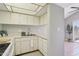 Bright, updated kitchen features white cabinetry, tile floors, and a modern faucet with natural light at 921 S Hacienda Dr, Tempe, AZ 85281
