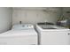 Laundry room showcasing white washer and dryer set with overhead shelving at 921 S Hacienda Dr, Tempe, AZ 85281