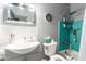 Updated bathroom with a gray and turquoise color scheme, featuring a tub-shower and decorative mirror at 1308 N 66Th St, Scottsdale, AZ 85257