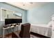 Bright blue bedroom with a window, ceiling fan, large monitor, and workspace at 1308 N 66Th St, Scottsdale, AZ 85257