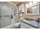 Bathroom features a white shower-tub combo, granite countertop, and vanity with framed mirror at 13428 N Hawthorn Dr, Sun City, AZ 85351