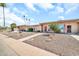 Beautiful one-story home with lovely rock landscaping, green bushes, and palm trees at 13428 N Hawthorn Dr, Sun City, AZ 85351