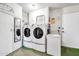 Well-lit laundry room with washer, dryer, freezer and overhead storage at 13428 N Hawthorn Dr, Sun City, AZ 85351
