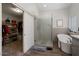 Bright bathroom featuring a glass shower, soaking tub, and walk-in closet with custom shelving at 14835 N 41St Pl, Phoenix, AZ 85032