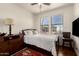 Comfortable bedroom with two windows, fan, and a dark wooden dresser at 15221 N Clubgate Dr # 2139, Scottsdale, AZ 85254