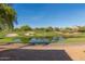 Picturesque view of a pond on a golf course, enhanced by mature trees and natural light at 15221 N Clubgate Dr # 2139, Scottsdale, AZ 85254