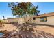 Landscaped backyard patio with stone seating, fountain, mature tree, and spiral staircase at 1611 W Palomino Dr, Chandler, AZ 85224