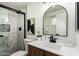 This bathroom features a marble tiled shower, wood vanity, and neutral color palette at 1611 W Palomino Dr, Chandler, AZ 85224