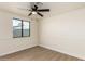 A cozy bedroom with hardwood floors, a ceiling fan, and a window with a view at 1611 W Palomino Dr, Chandler, AZ 85224