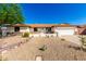 Charming single-story home with desert landscaping, a stone facade, and a two-car garage at 1611 W Palomino Dr, Chandler, AZ 85224
