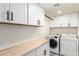The laundry room features a washer and dryer, white cabinets, and a wooden folding table at 1611 W Palomino Dr, Chandler, AZ 85224