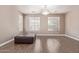 Empty room with an elegant chandelier, three windows, and wood floors at 16217 N 154Th Dr, Surprise, AZ 85374