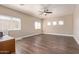 Empty room with three windows, ceiling fan, and wood floors at 16217 N 154Th Dr, Surprise, AZ 85374