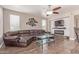 Living room featuring a fireplace, modern decor, a ceiling fan and lots of light at 16217 N 154Th Dr, Surprise, AZ 85374