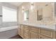This bathroom features dual sinks, marble counters, and stone tile accent wall at 16217 N 154Th Dr, Surprise, AZ 85374