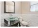 This powder room features a glass bowl sink, stone accent wall, and modern lighting at 16217 N 154Th Dr, Surprise, AZ 85374