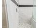 Shower featuring white marble-style walls and mosaic tile flooring at 16217 N 154Th Dr, Surprise, AZ 85374