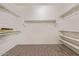 Bright walk-in closet with shelves, hanging rods, and wood-look floor at 16217 N 154Th Dr, Surprise, AZ 85374