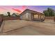 Backyard with patio, privacy wall, and the exterior of the house at 16783 W Taylor St, Goodyear, AZ 85338