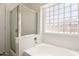 Bright bathroom features a soaking tub with a glass block window and a separate glass shower at 16783 W Taylor St, Goodyear, AZ 85338