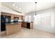 Eat-in kitchen features wood cabinets, black appliances, tile flooring and lots of natural light at 16783 W Taylor St, Goodyear, AZ 85338