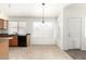 Bright eat-in kitchen features wood cabinets, black appliances, tile flooring and lots of natural light at 16783 W Taylor St, Goodyear, AZ 85338