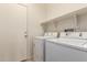 Laundry room with white washer and dryer and shelf above at 16783 W Taylor St, Goodyear, AZ 85338