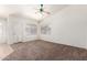 Open living room with neutral walls, ceiling fan, and carpet flooring, with tile entryway at 16783 W Taylor St, Goodyear, AZ 85338