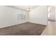 Bright living room featuring neutral walls, carpet flooring, and a large window at 16783 W Taylor St, Goodyear, AZ 85338
