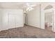 Open bedroom with carpet, ceiling fan, access to the en-suite bathroom and large closets at 16783 W Taylor St, Goodyear, AZ 85338