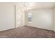 Large bedroom boasts a fan, access to en-suite bathroom, arched windows, and plush carpet at 16783 W Taylor St, Goodyear, AZ 85338