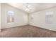 Spacious main bedroom features carpet floors, arched windows, and a ceiling fan at 16783 W Taylor St, Goodyear, AZ 85338