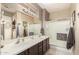 Bathroom featuring double sinks, modern fixtures, and a glass-enclosed shower at 17359 W Calistoga Dr, Surprise, AZ 85387
