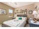 Inviting bedroom with soft colors, ceiling fan, and a bright window overlooking the yard at 17359 W Calistoga Dr, Surprise, AZ 85387