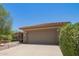 Charming front exterior showcasing desert landscaping with vibrant green bushes and desert rock at 17359 W Calistoga Dr, Surprise, AZ 85387