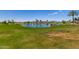 Golf course view with a pond, fountain, and mountain backdrop at 17359 W Calistoga Dr, Surprise, AZ 85387