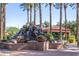 Beautifully landscaped water feature with cascading rocks, lush greenery, and towering palm trees creates a serene ambiance at 17359 W Calistoga Dr, Surprise, AZ 85387