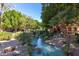Scenic water feature with lush trees, flowing water, and rock details, creating a tranquil and inviting atmosphere at 17359 W Calistoga Dr, Surprise, AZ 85387